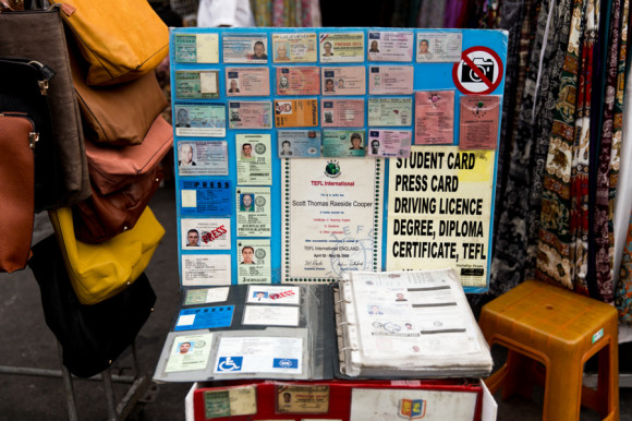Una mesa y un cartón vertical lleno de documentos falsos y a la vista de todo el mundo.